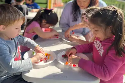 Children conducting hands-on outdoor science experiments and exploration in a preschool science learning center at Newport Ave Preschool