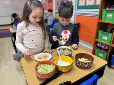 Preschool children enjoying a culinary activity representing nutritious on-site meal preparation at Newport Ave Preschool