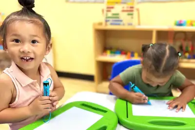 Teacher guiding young children through a hands-on art activity in a Montessori-inspired preschool classroom at Newport Ave Preschool